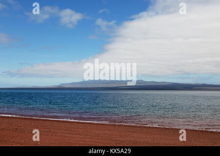 Red volcanic sand beach on Rabida Island looking across to Santiago Island, Galapagos Islands Ecuador South America Stock Photo