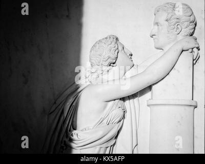 Bas relief of an ancient woman (roman or greek) hugs a man's bust. Really intense image Stock Photo