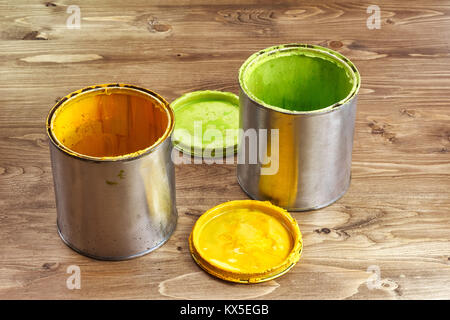 green and yellow paint cans on a rustic wooden background Stock Photo