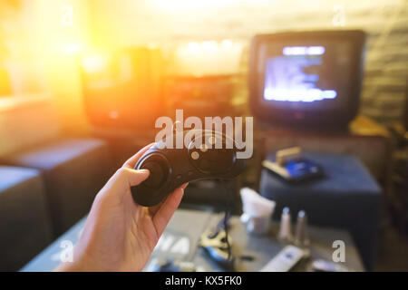 A young man holding game controller playing video games. Oldschool console. Gaming concept. Stock Photo