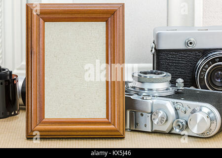 retro cameras and empty wooden photo frame closeup. old memories concept. Stock Photo