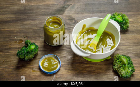 Baby food. Baby puree from broccoli. On a wooden background. Stock Photo
