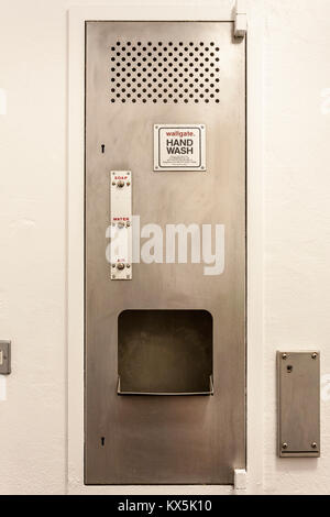 Wall mounted stainless steel hand wash dryer unit in a commercial washroom. Stock Photo
