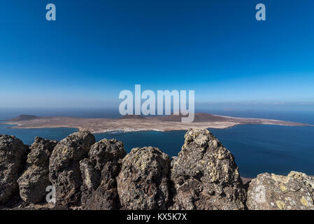 Der Blick auf die Insel La Graciosa mit der Mauer aus Lavagestein vom Mirador del Rio auf Lanzarote Stock Photo