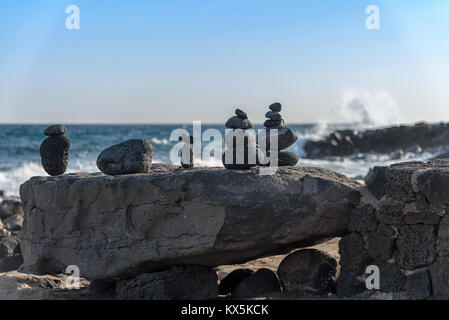 Steinskulpturen aus aufgeschichteten Lavagestein an der Küste von Costa Teguise auf Lanzarote Stock Photo