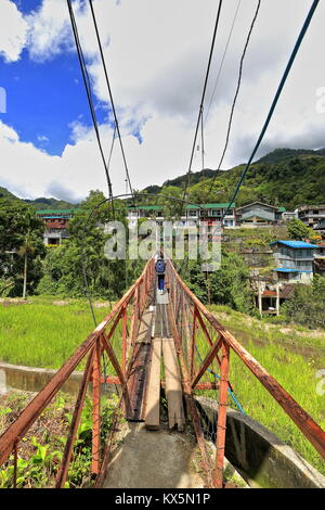 The suspension or hanging bridge in Banaue connects the downtown market area with the Batad road-used by many students to go to their school across th Stock Photo