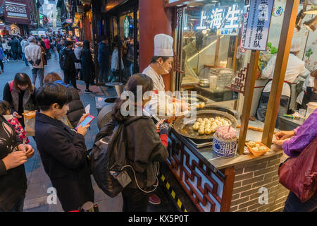 People buying pan fried Shanghai dumpling at a food stall Stock Photo