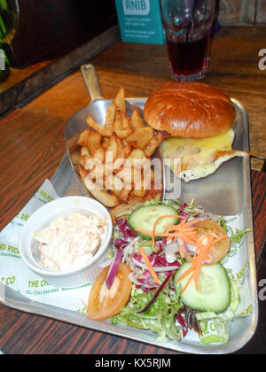 English pub lunch of Chicken burger, chips/fries with side salad and coleslaw Stock Photo