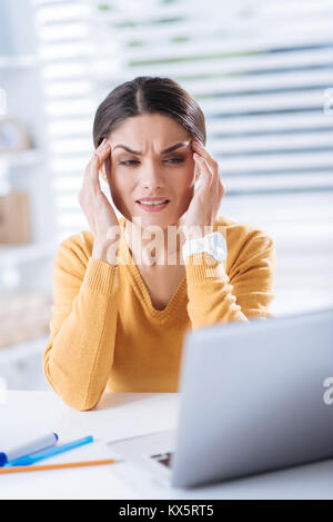 Exhausted worker touching the forehead while experiencing terrible migraine Stock Photo