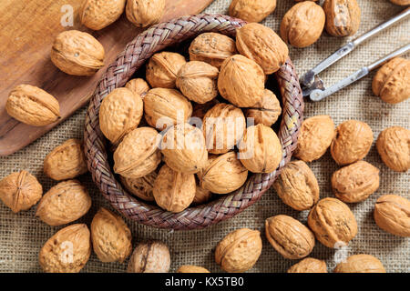 Walnuts in a small basket on a table Stock Photo