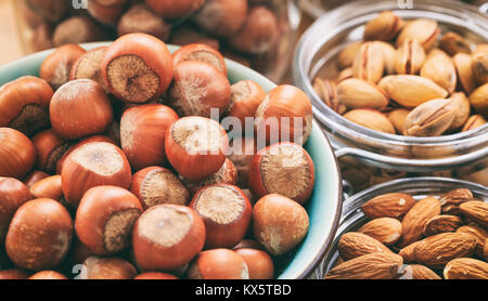 Hazelnuts, almonds and pistachios in bowls Stock Photo
