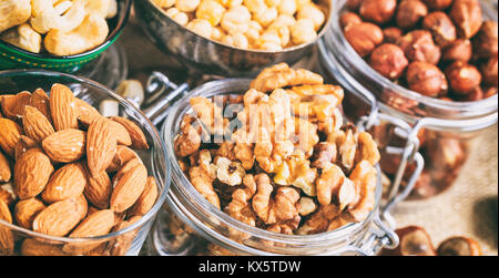 Various nuts in bowls on a table Stock Photo