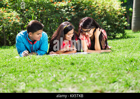 3 Indian College Friends Together Lying Grass In Park Fun Stock Photo