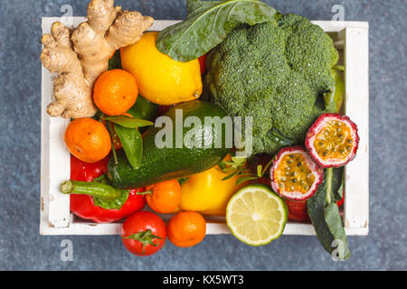 Fresh fruits and vegetables in a white wooden box. A healthy vegetarian farm food concept.