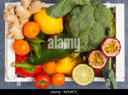 Fresh fruits and vegetables in a white wooden box. A healthy vegetarian farm food concept.