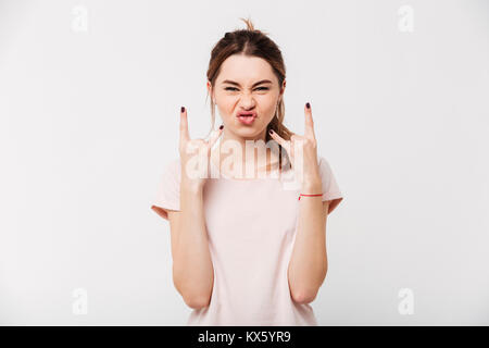 Portrait of a funny pretty girl showing rock gesture with fingers isolated over white background Stock Photo
