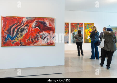 People look at Marc Chagall paintings Le cheval roux and triptych: Resistance, Resurrection, Liberation, Musée National Marc Chagall, Nice Stock Photo