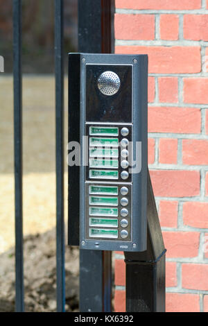 Intercom system besides gate at entrance to apartment block Stock Photo