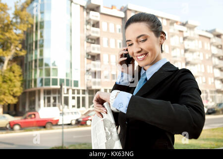 smiling businesswoman on the phone checking the time, concept-busy woman Stock Photo