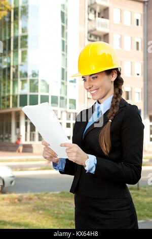 young architect with hard hat reading , outdoor Stock Photo