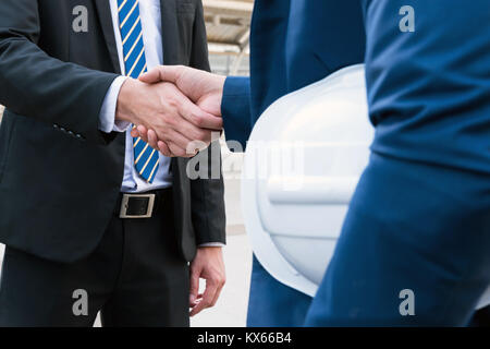 Business Partnership ,teamwork and success industry concept. businessman shaking hands finishing up a meeting with engineer. Stock Photo