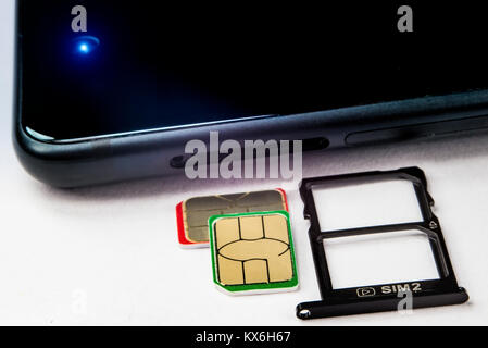 SIM card and tray for them next to the phone Stock Photo