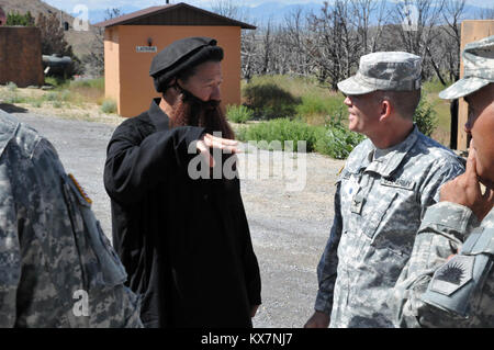 Sgt. 1st Class Paul Hernandez with the 260th Military Intelligence Battalion out of Miami, Fla., participating as a role player during Panther Strike 2014 at Camp Williams, Utah, explains aspects of the training exercise to Col. Steven Buethe, the commander of the 100th Troop Command, California Army National Guard, who visited the training site June 18. Panther Strike is an annual training event that brings together military intellegence Soldiers from across the U.S. and partner nations for a large-scale, dynamic, full-spectrum intelligence exercise. (U.S. Army Photo National Guard photo/Spc. Stock Photo