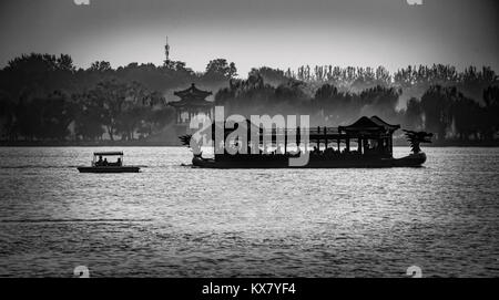 Silhouettes of a dragon boat and small boat on Kunming Lake on the grounds of the Summer Palace in Beijing, China Stock Photo