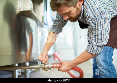 Bearded Technician Wrapped up in Work Stock Photo