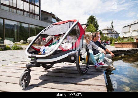 Senior couple with grandchildren in jogging stroller. Stock Photo