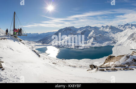 VAL CENIS, FRANCE - DECEMBER 31, 2017 : People enjoying views of Mont Cenis lake and the surrounding mountains from the platform on the Col de la Met, Stock Photo