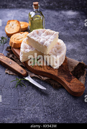Camembert cheese with rosemary on wooden board Stock Photo