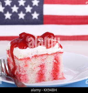 Piece of cake with cherries on a plate with American flag in background Stock Photo