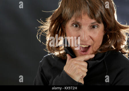 Attractive Middle aged woman with layered brown hair with a surprised expression with back lighting Stock Photo