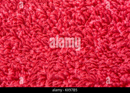 Abstract textures suitable for a background, depicting a red terry towelling towel in close up, magnified view. Stock Photo