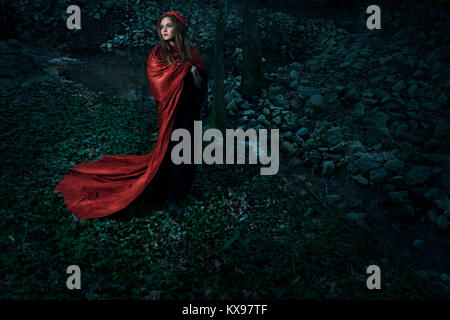 Young woman wrapped in red cape and hood Stock Photo