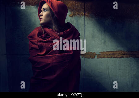 Young woman wrapped in red cape and hood Stock Photo