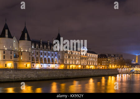 Night view of Conciergerie Castle and Pont Notre-Dame bridge over river Seine. Castle Conciergerie is a former prison located on west of the Cite Isla Stock Photo