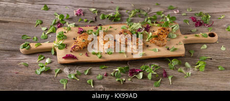 Fresh freshly fried delicious slices of meat on a wooden board with fresh herbs. Appetizing steaks on a wooden board. Stock Photo