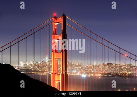 Golden Gate Bridge Close-up with San Francisco Skyline Background on a clear winter night. Stock Photo