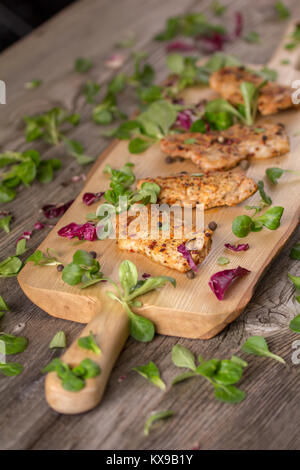 Fresh freshly fried delicious slices of meat on a wooden board with fresh herbs. Appetizing steaks on a wooden board. Stock Photo