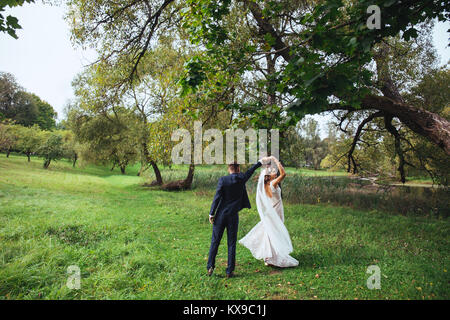 Happy wedding couple holding big white love letters and kissing Stock Photo