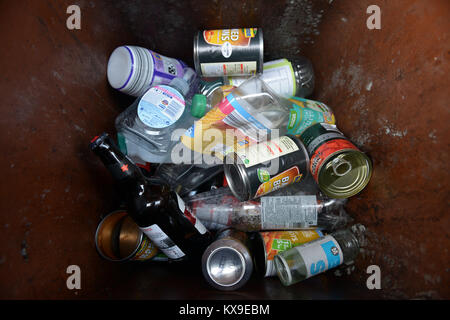 Plastic and glass bottles, glass jars and tin containers in a recyling bin. Stock Photo