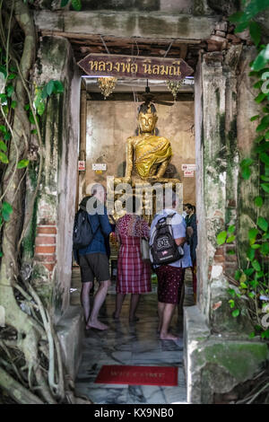Western tourist visiting the Statue of Buddha, Ordination Hall, Bang Kung Camp, Samut Songkhram, Thailand.