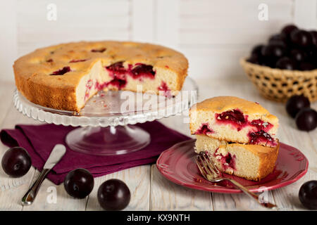 Homemade plum cake on a glass stand. Selective focus. Stock Photo
