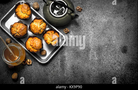 Honey muffins with a teapot. On a rustic background. Stock Photo