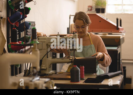 Worker sewing leather in workshop Stock Photo
