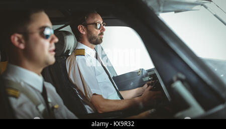 Pilot and copilot flying an airplane Stock Photo - Alamy