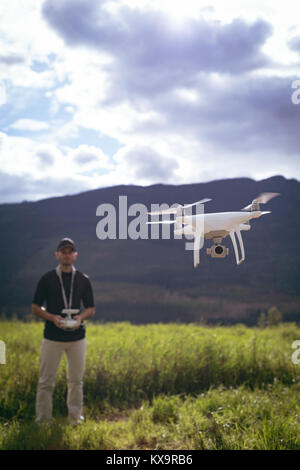 Man operating drone flying by remote control Stock Photo