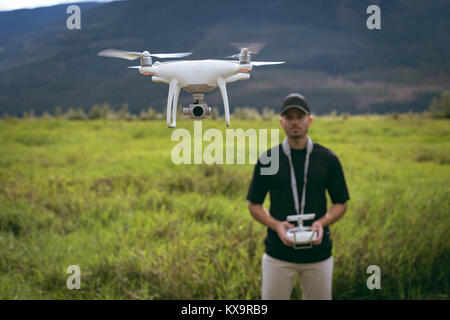 Drone in front of man with remote controller in his hands Stock Photo